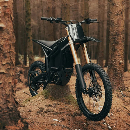 Talaria Komodo 32 kW Offroad Schwarz im Wald in Front-Seitenansicht